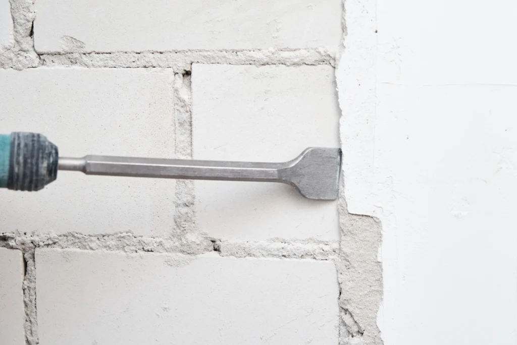 breaking through brick wall with chisel tool 2026 09 22 02 58 01 utc