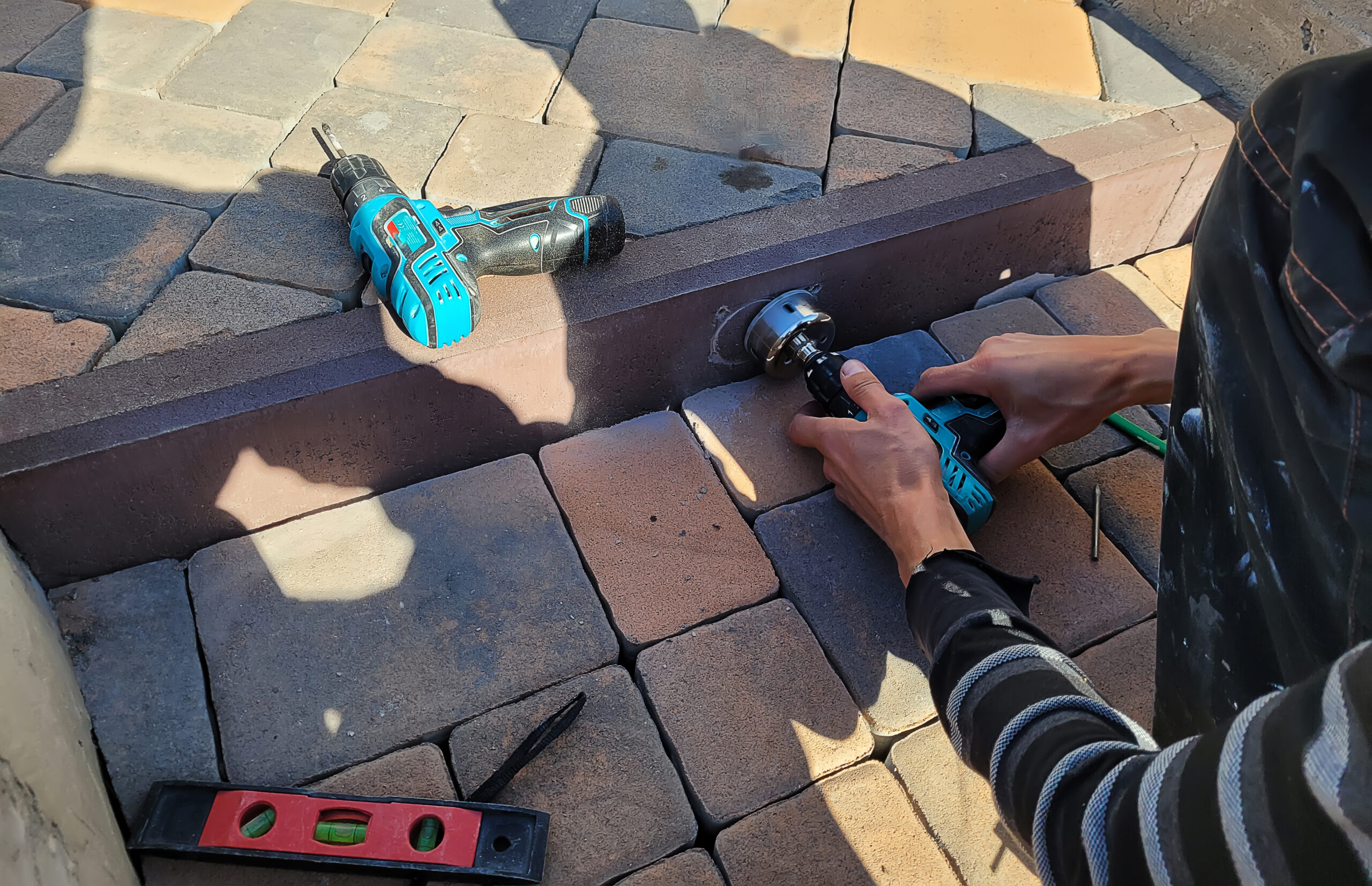construction worker drilling into paver block outs 2026 09 23 21 32 38 utc scaled